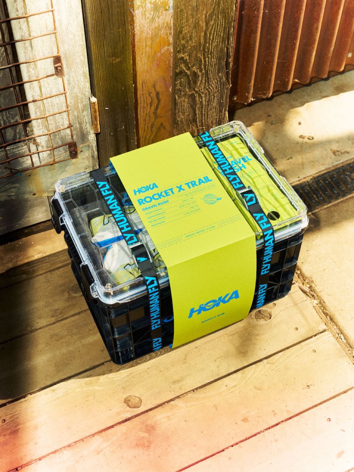 HOKA Rocket X Trail Gravel Rush launch kit: printed belly band and Fly Human Fly webbing straps on a latching crate